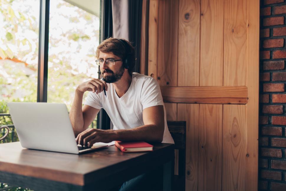 Free Image of Pensive man with beard using laptop 