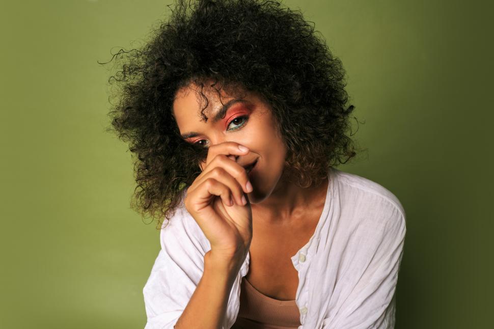 Free Image of Woman with colourful make up posing over green background 