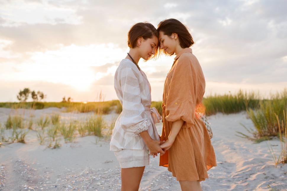 Free Image of Two affectionate women standing face to face on beach  