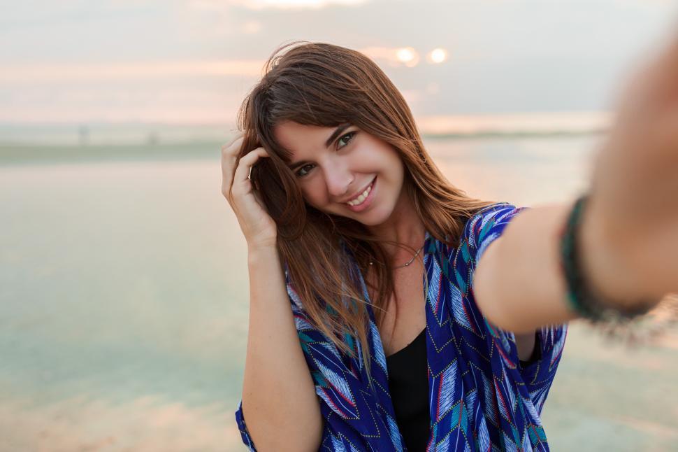 Free Image of Lovely romantic woman making self portrait on the empty beach 