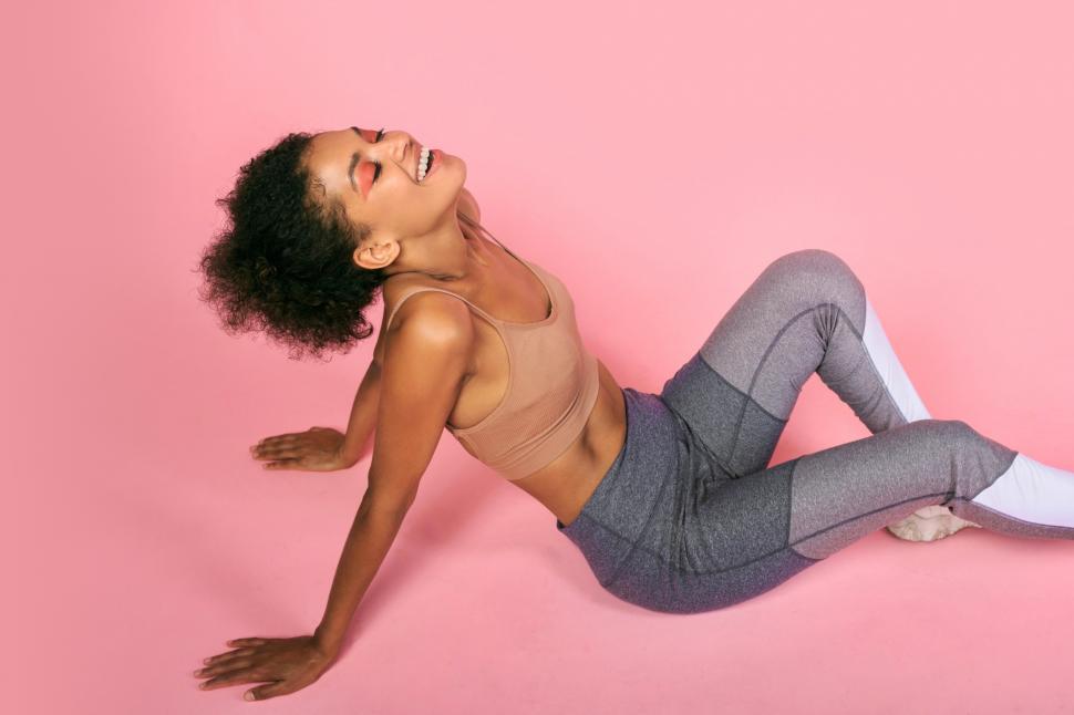 Free Image of Woman in fitness gear sitting on the ground 