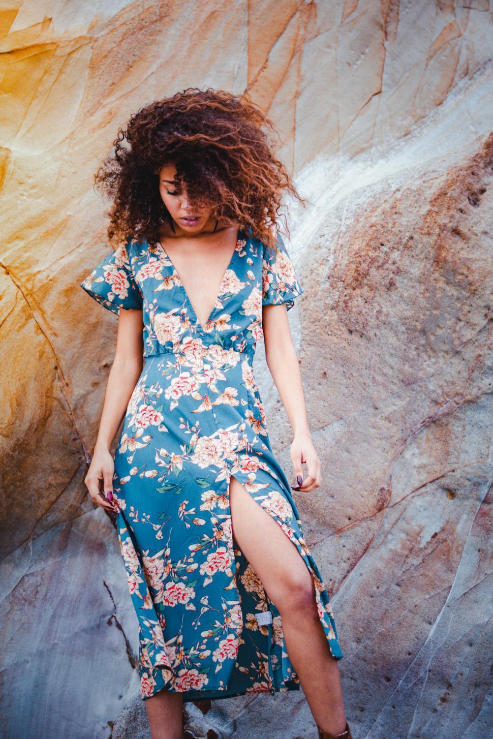 Free Image of woman in an elegant dress in the shore in a rocks background 