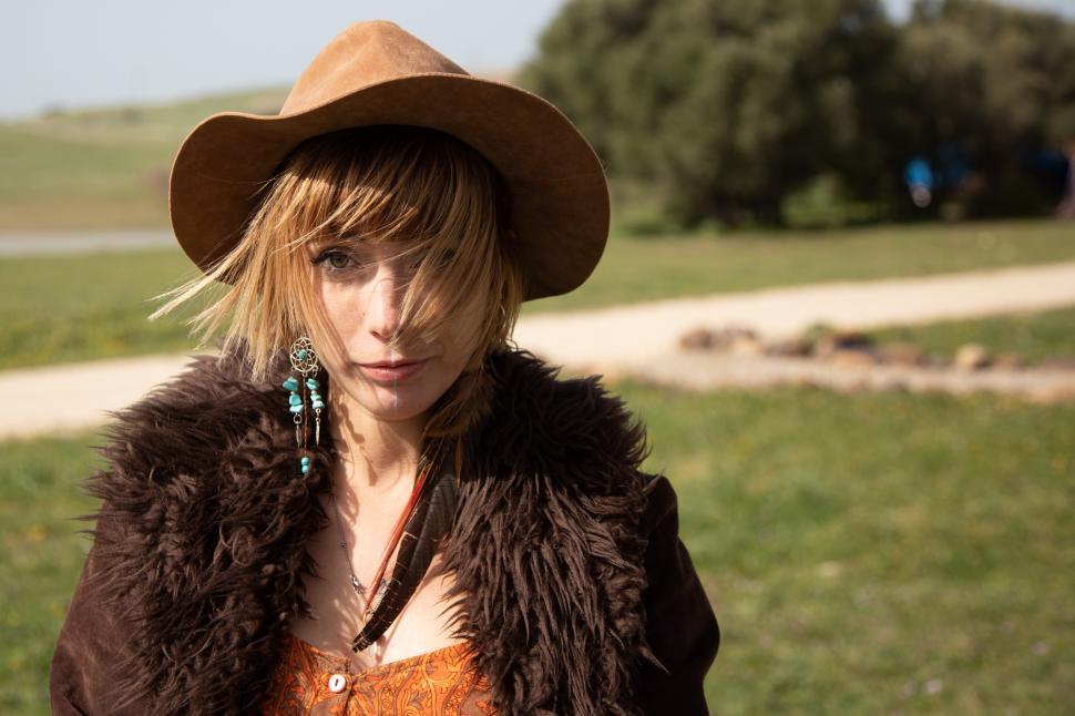 Free Image of a hipster girl in a hat outdoors natural background 