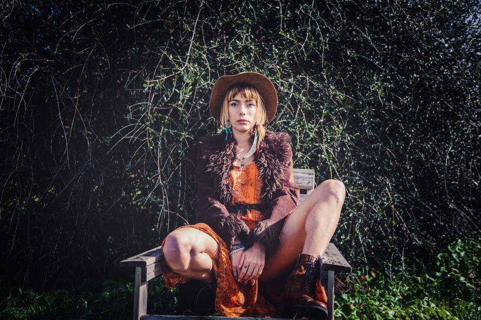 Free Image of a young boho model posing in wooden chair 
