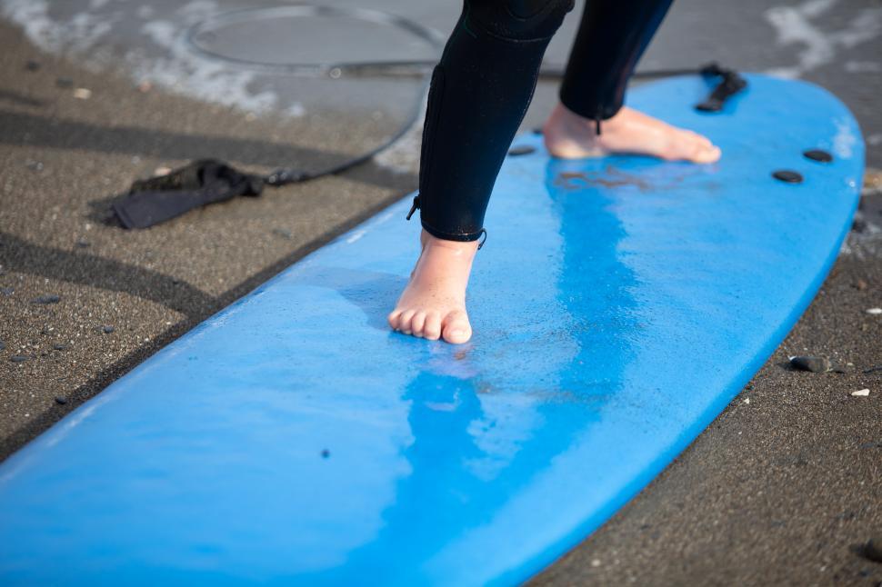 Free Image of kid standing on a surfboard 