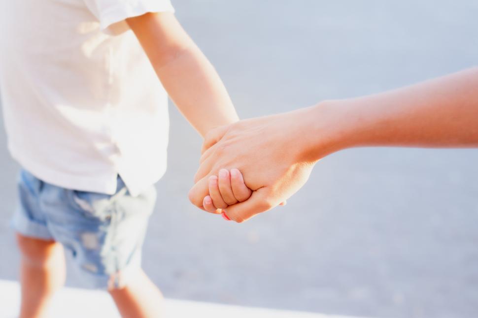 Free Image of a mother giving her hand to her son close up 