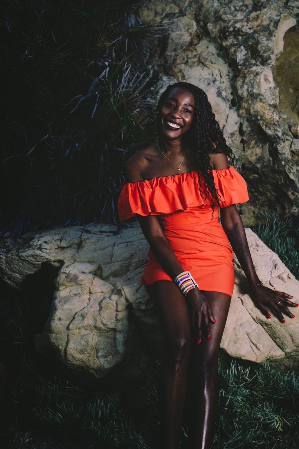 Free Stock Photo of Portrait of young black woman wearing a red dress at the beach