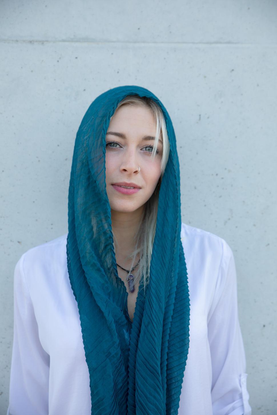 Free Image of A blonde young trendy woman posing in the city with a scarf 