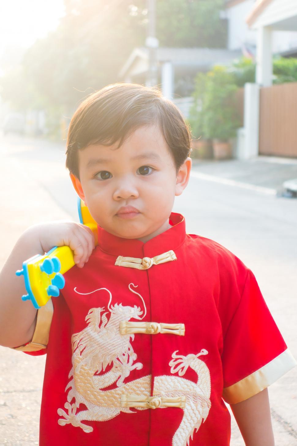 Free Image of Young chinese boy smiling and happy in Chinese new year costume 
