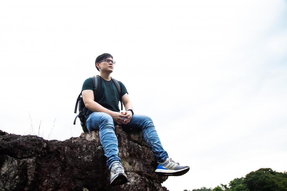 Free Image of Traveler Man relaxing sitting on top of cliff 