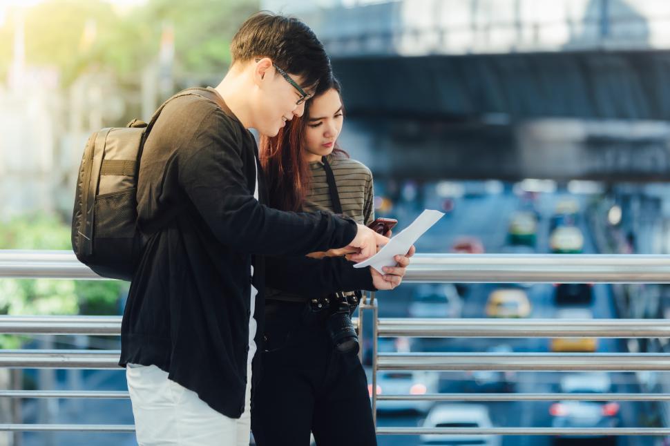 Free Image of Happy young couple of travelers holding map 