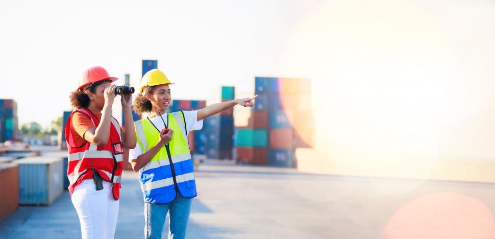 Free Image of . Black female dock workers with binoculars and walkie talkie 