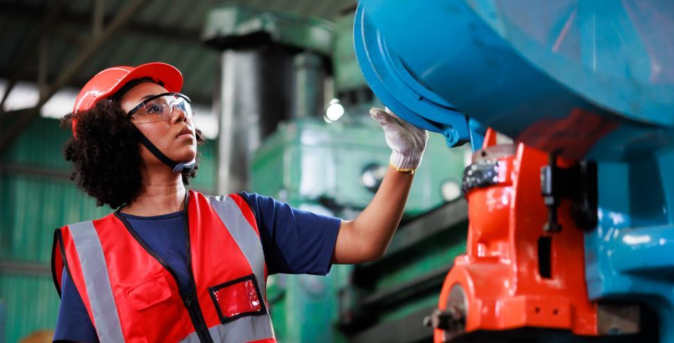 Free Image of Woman wearing safety goggles controls machine 
