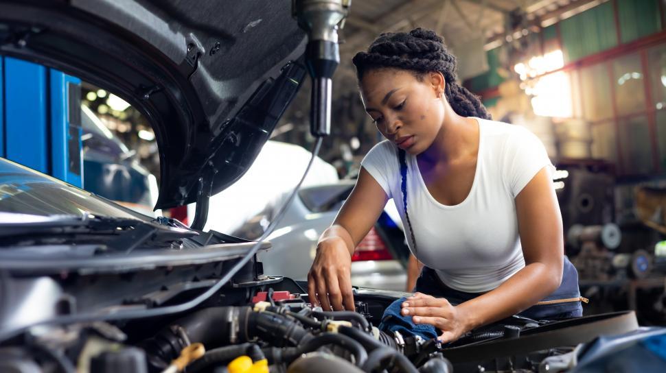Free Image of Woman working under the hood on car engine 