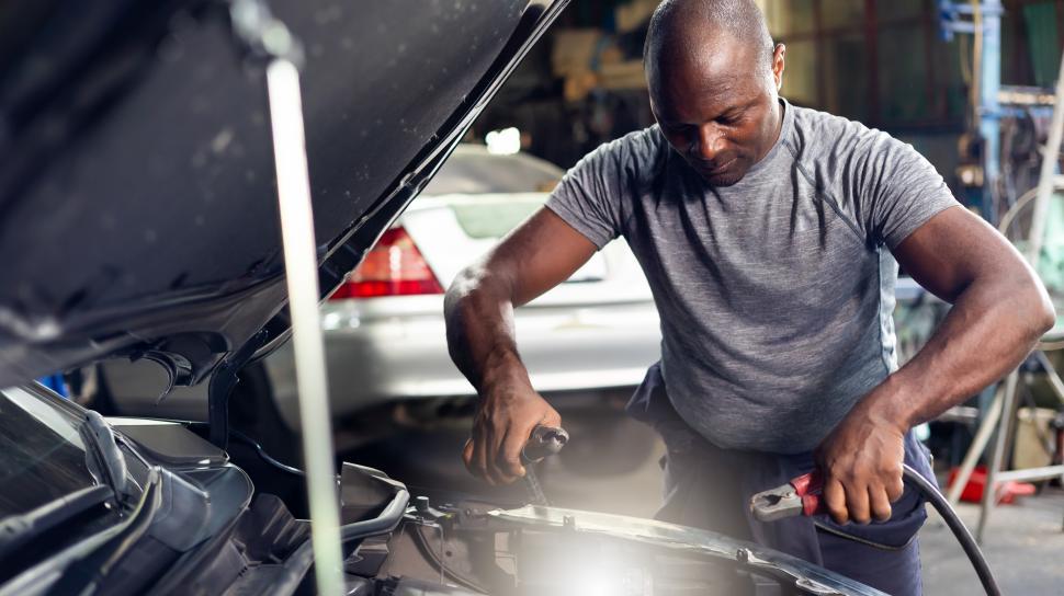 Free Image of Man connecting jumper cables to battery 