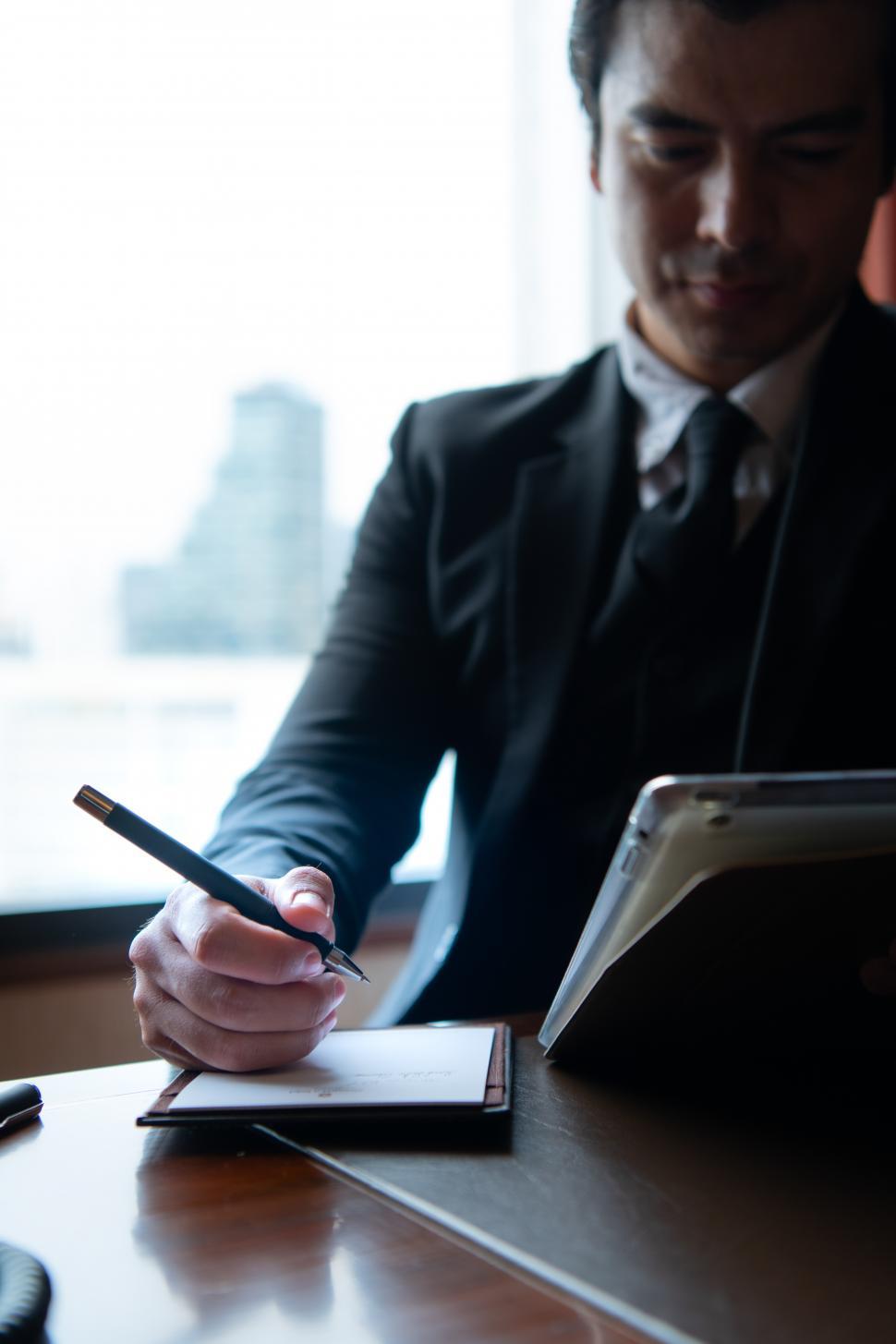 Free Image of A young businessman monitors and keeps track of tasks in his office 
