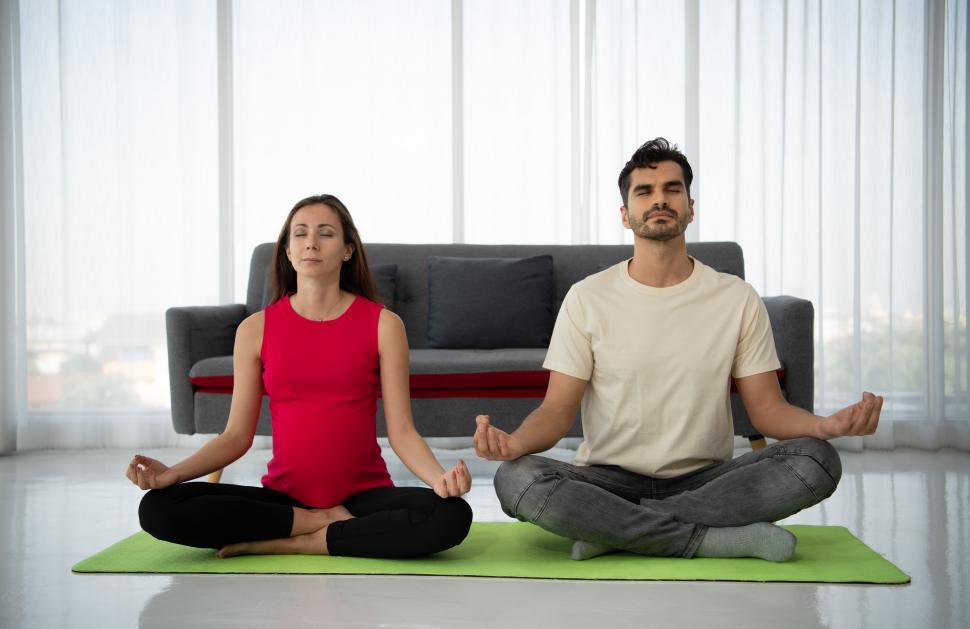 Free Image of A pregnant woman meditates with her husband 
