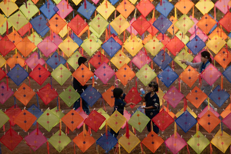 Free Image of A little boy and girl enjoy playing with kites in rural Thailand 
