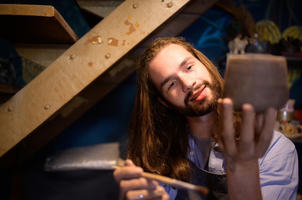Free Image of Pottery artist examining latest ceramic creation before it dries 