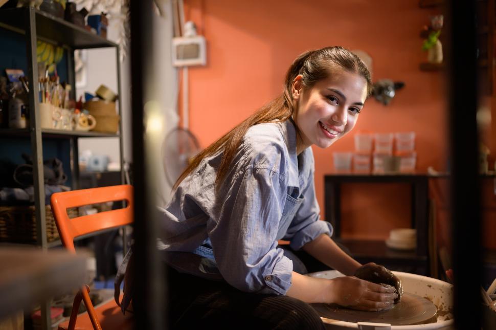 Free Image of Young woman throwing pots on spinning wheel 