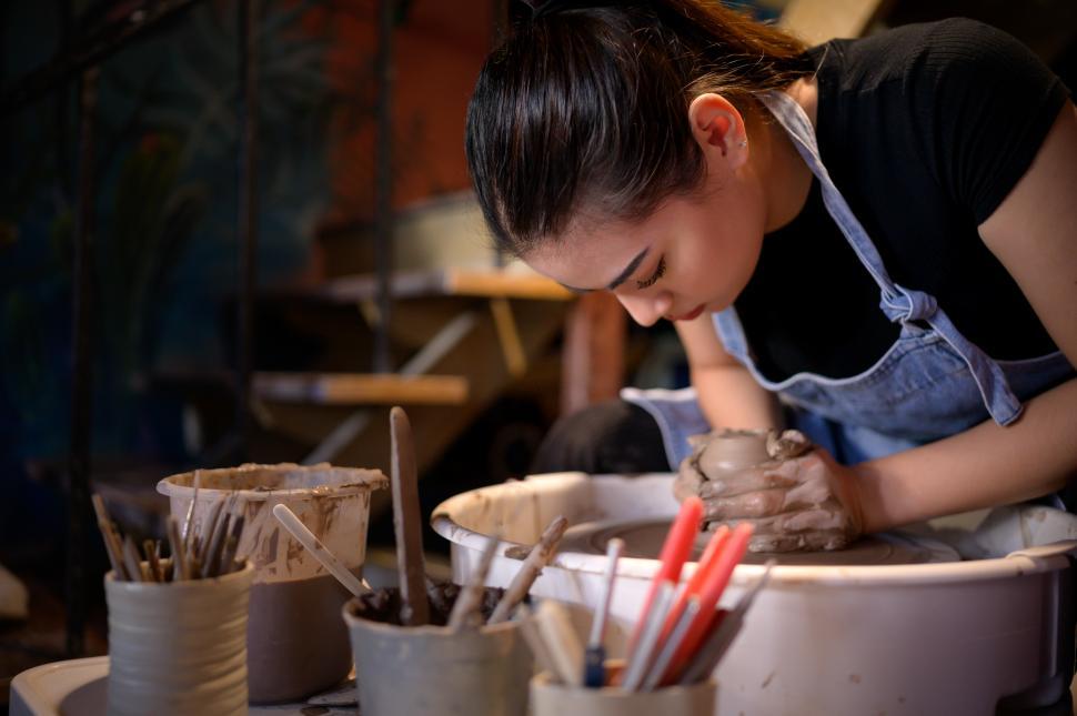 Free Image of Potter centering clay on pottery wheel, preparing to throw 