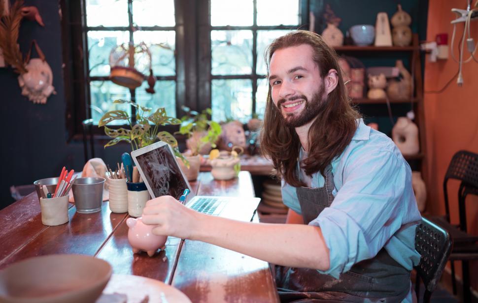 Free Image of A young businessman owns a small pottery business 