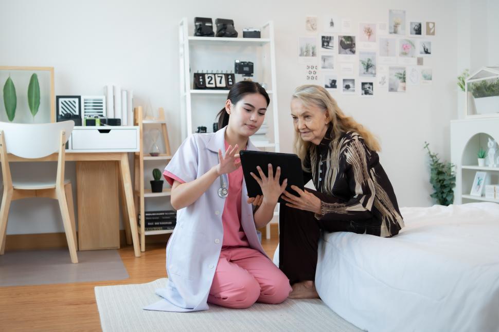 Free Image of In home health care worker working with elderly woman in bedroom 