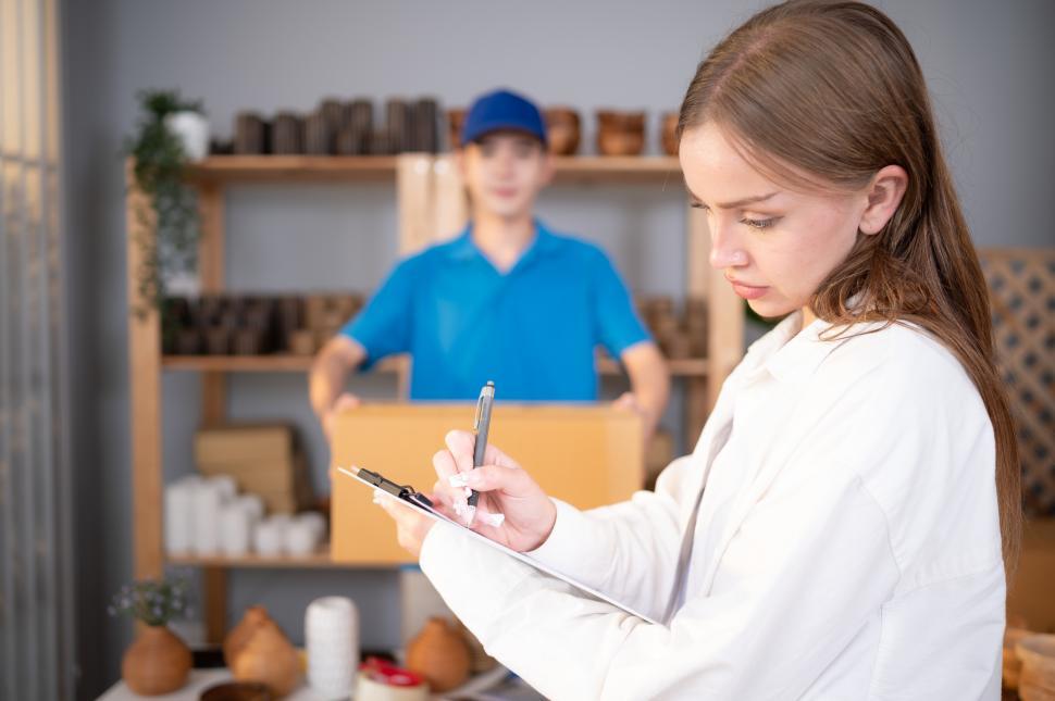 Free Image of Woman signs for delivery while driver waits in the background 