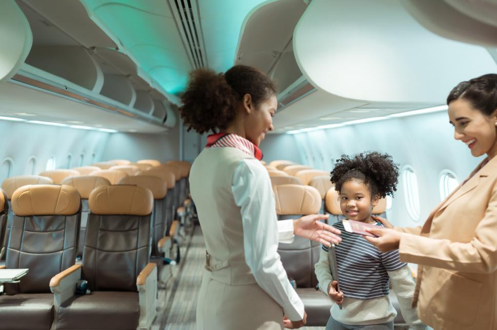 Free Image of Flight attendant greets passengers as they enter the aircraft for international flight 