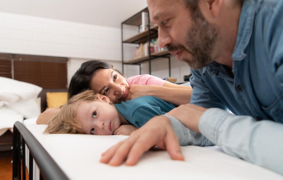Free Image of Mother and father help the little boy wake up from his nap, 