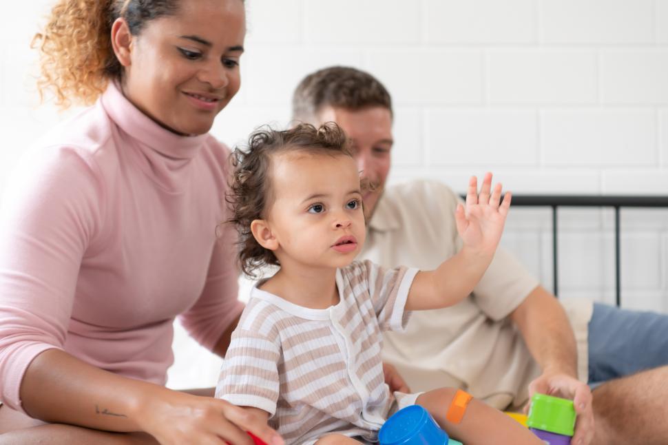 Free Image of Parents with little girl playing on the bed 