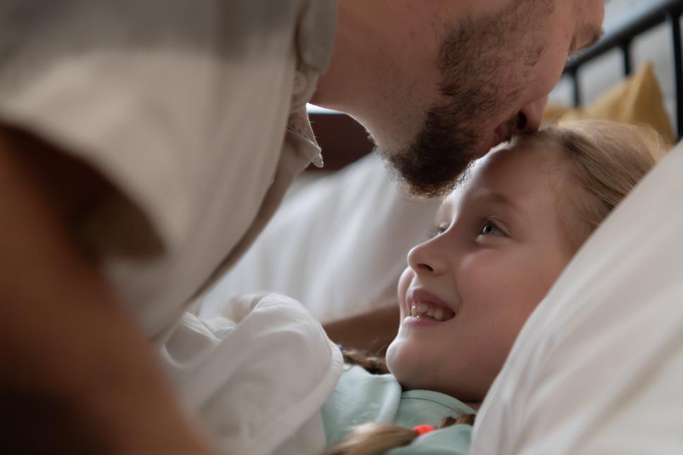 Free Image of Before retiring to night, a father gives a goodnight kiss 