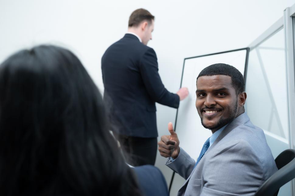 Free Image of Businessmen in a meeting where a guy is using a whiteboard 