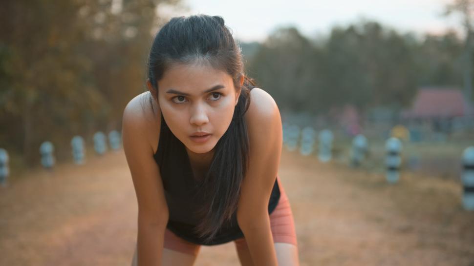 Free Image of A young woman is running in nature outdoor at sunset 
