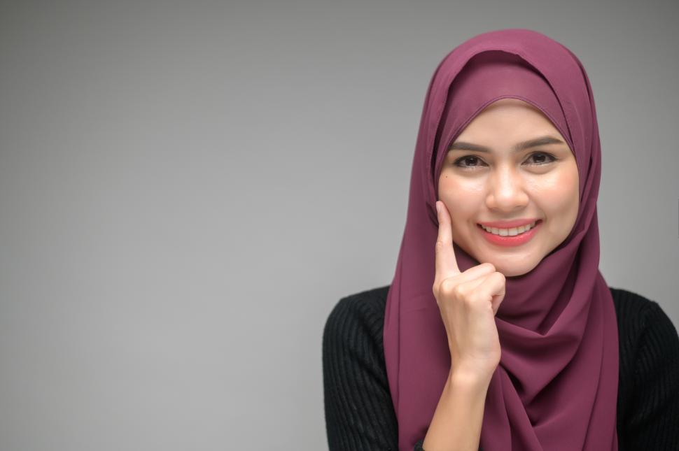 Free Image of Studio photo of one muslim woman with one finger held to her face 