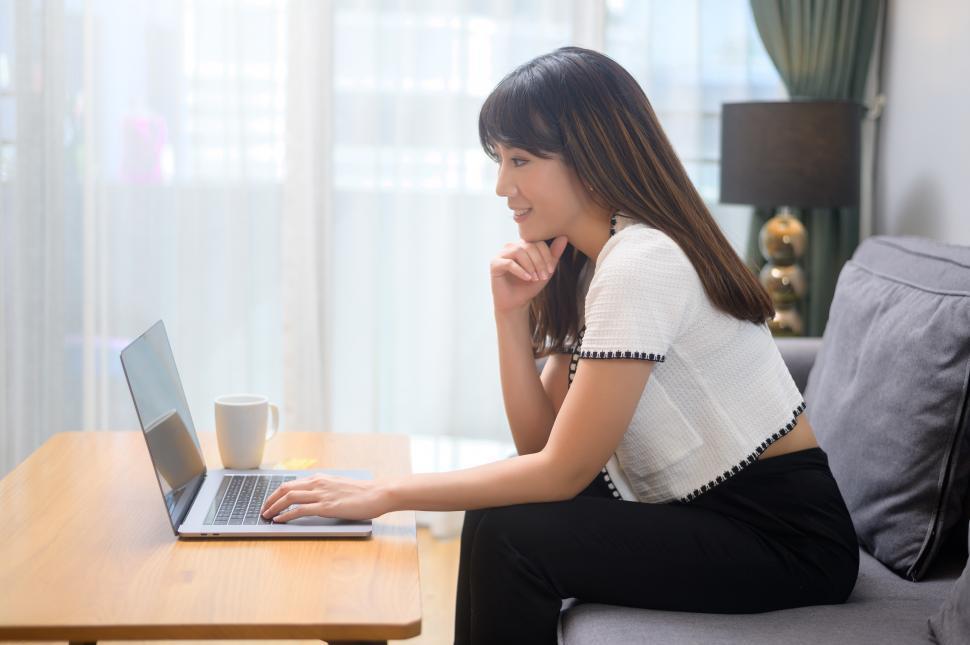 Free Image of Young female working with her laptop and having a cup of coffee, 