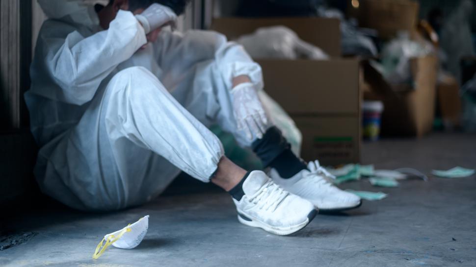 Free Image of Worker in PPE exhausted and tired in Waste recycling plant 
