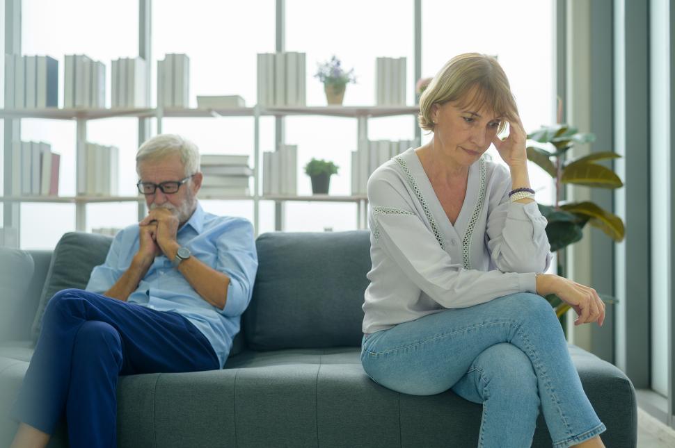 Free Image of Two seniors citizens looking stressed and upset, sitting on a couch 