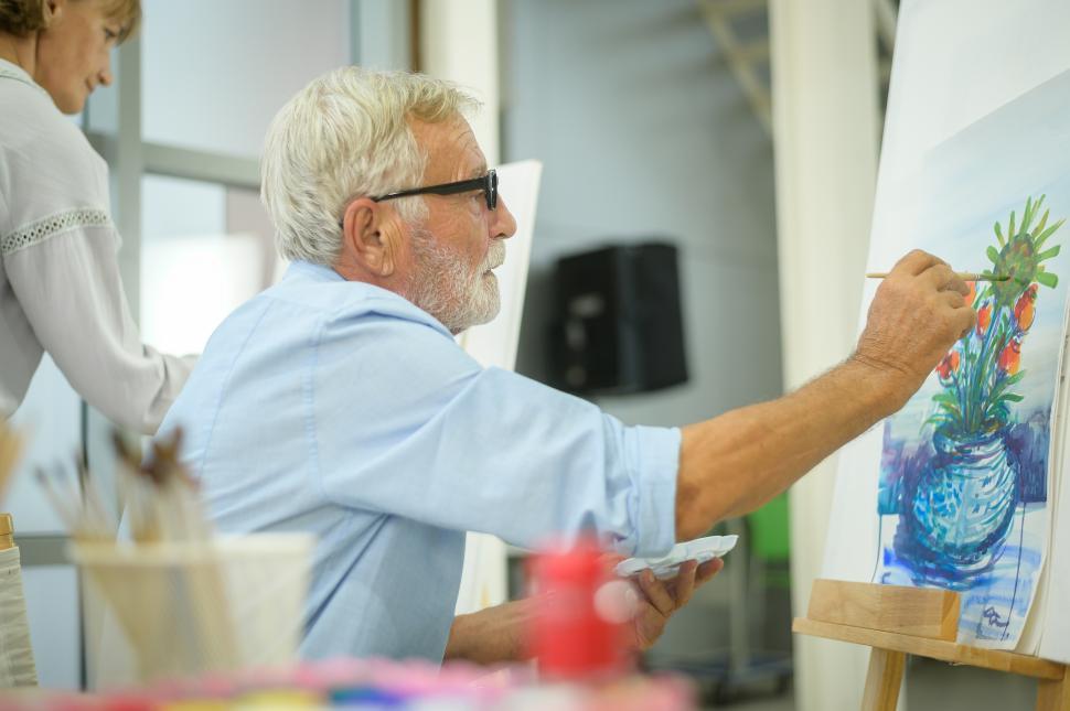 Free Image of Elderly man painting a still life on canvas in home studio 