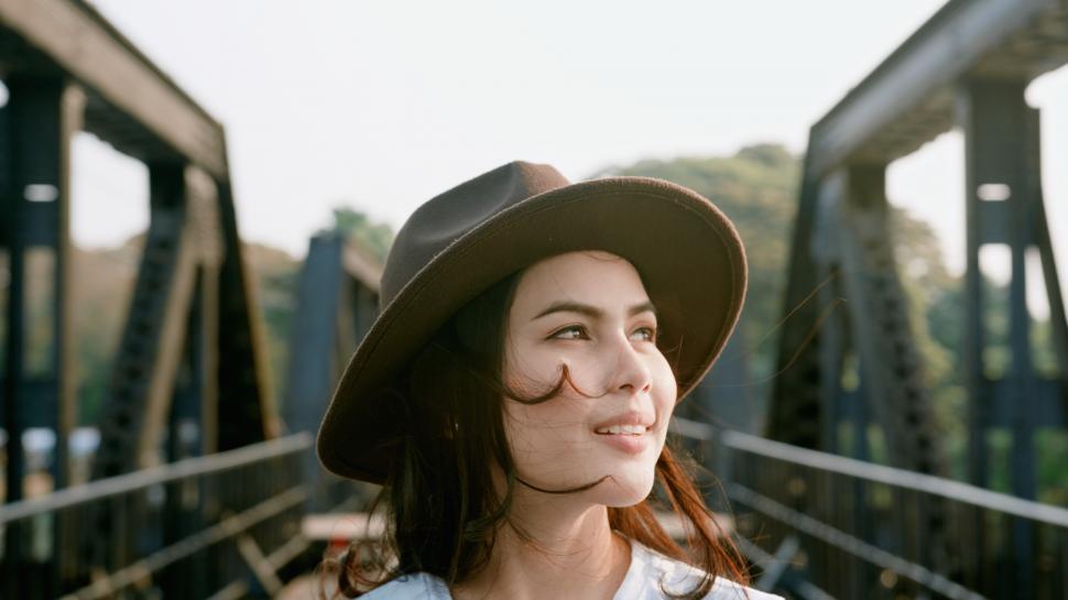Free Image of A woman is enjoying a walk on a bridge in the city 