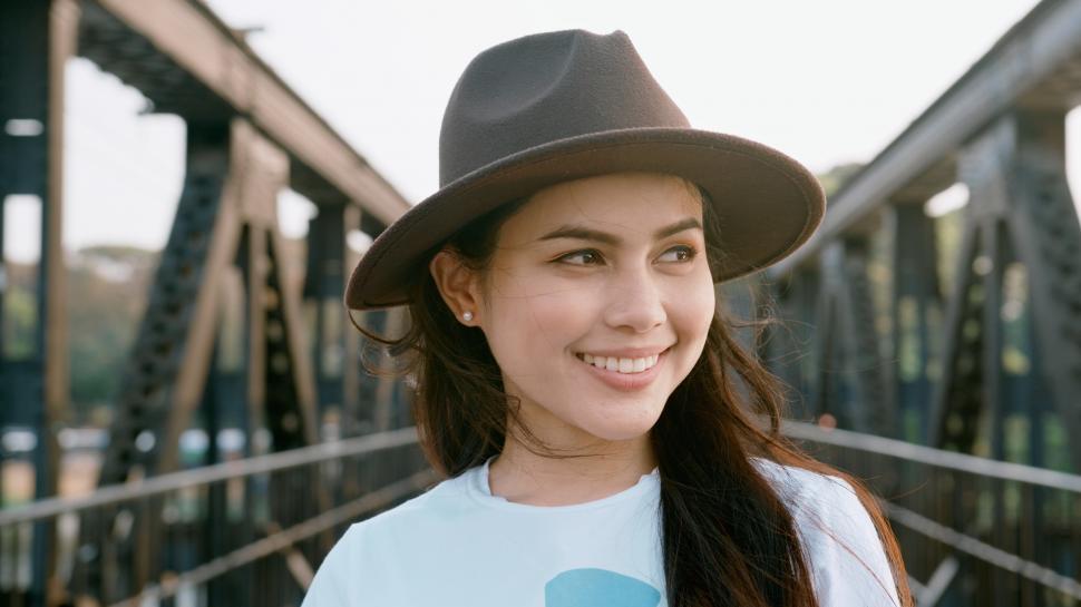 Free Image of A beautiful woman is enjoying with scenic city view, walking on a bridge 