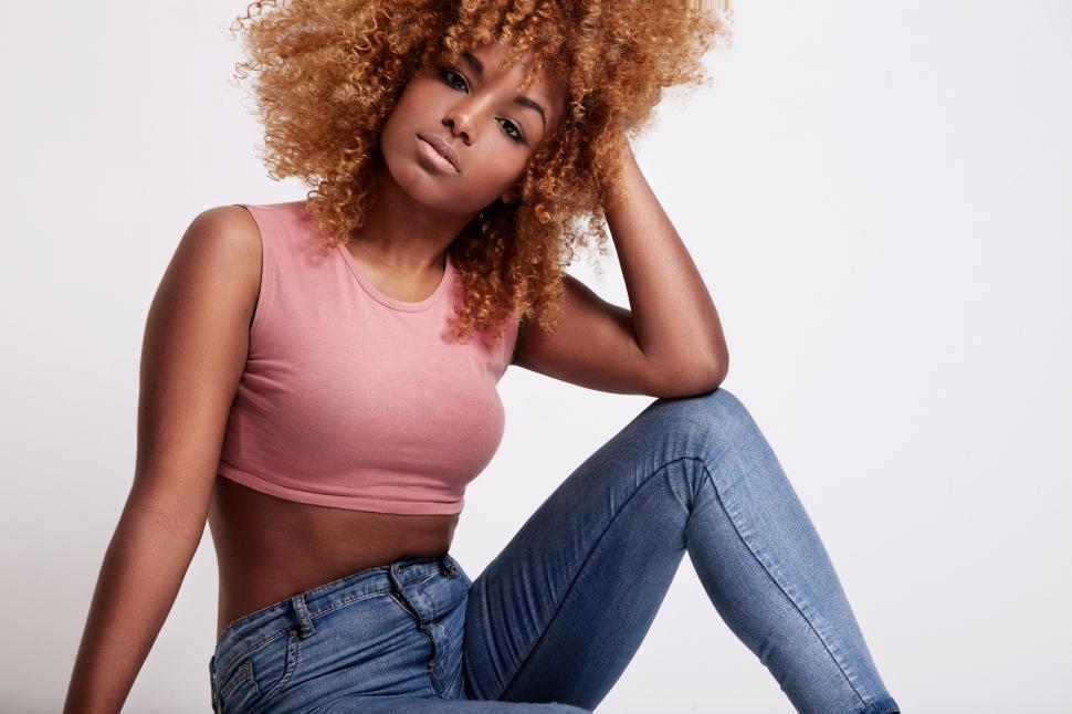 Free Image of Young woman sits in the studio, hand in hair 