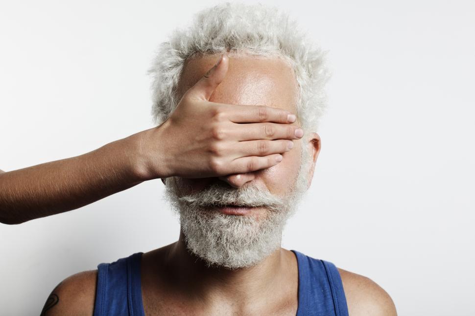 Free Image of Womans hand covering the eyes and nose of a mans face 