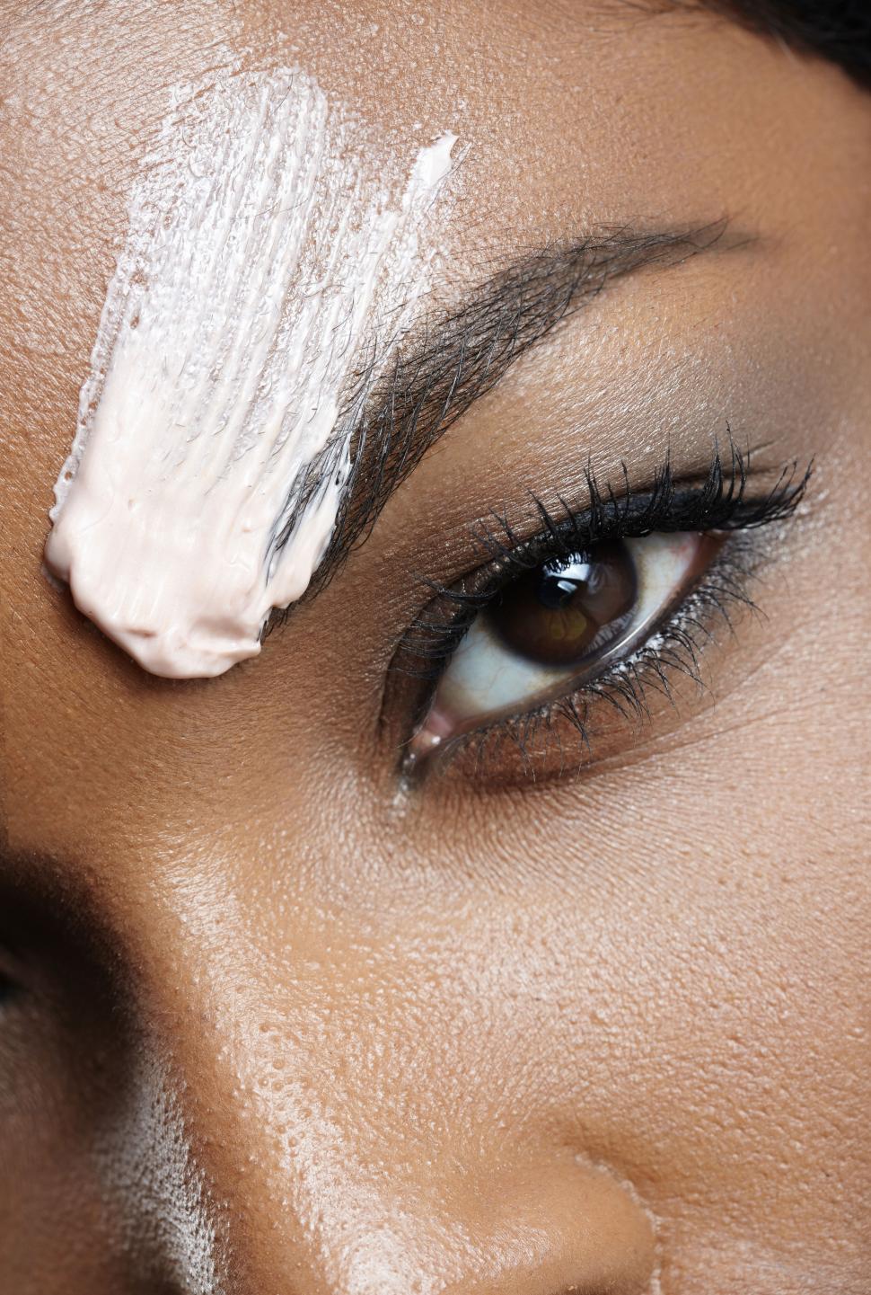Free Image of black woman face closeup with cosmetic cream smear 