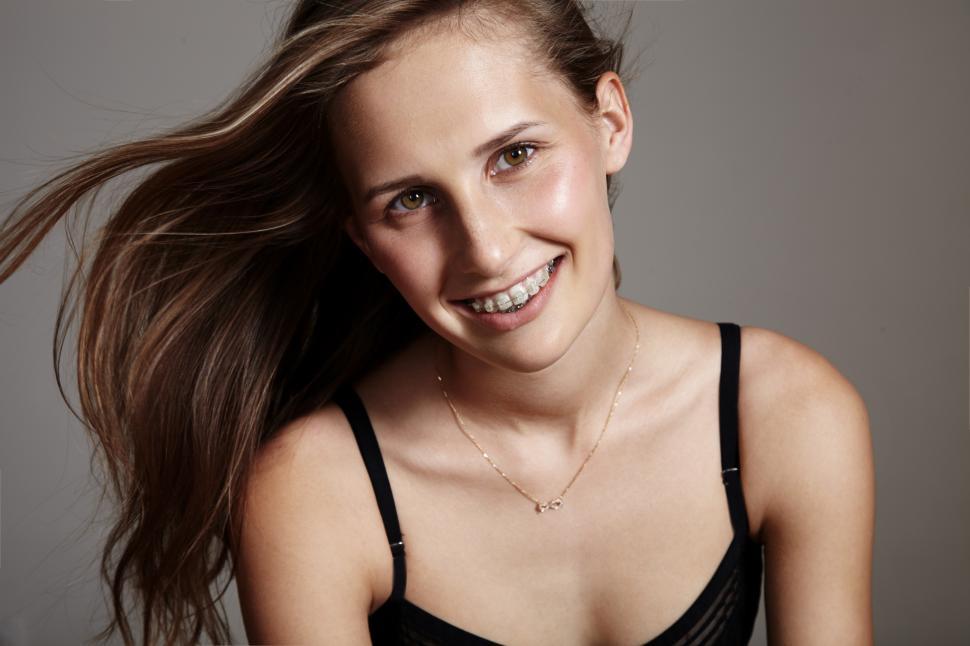 Free Image of smiling woman with a blowing hair and braces 