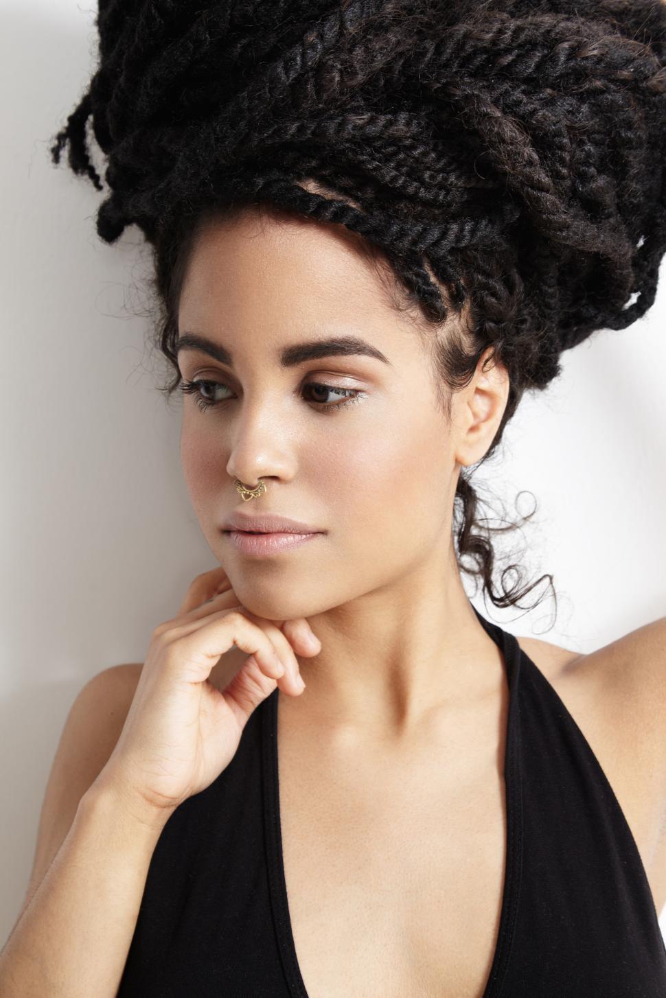 Free Image of pretty woman with dreadlocks pinned up, looking off camera 