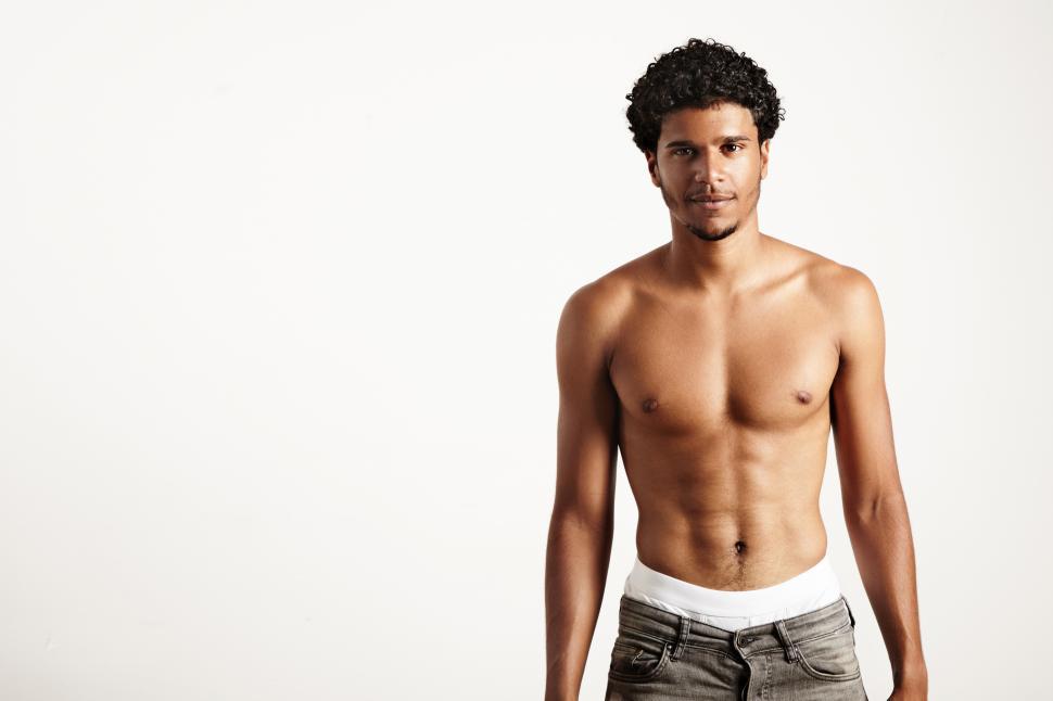 Free Image of shirtless young smiling man wears jeans, looking at the camera 