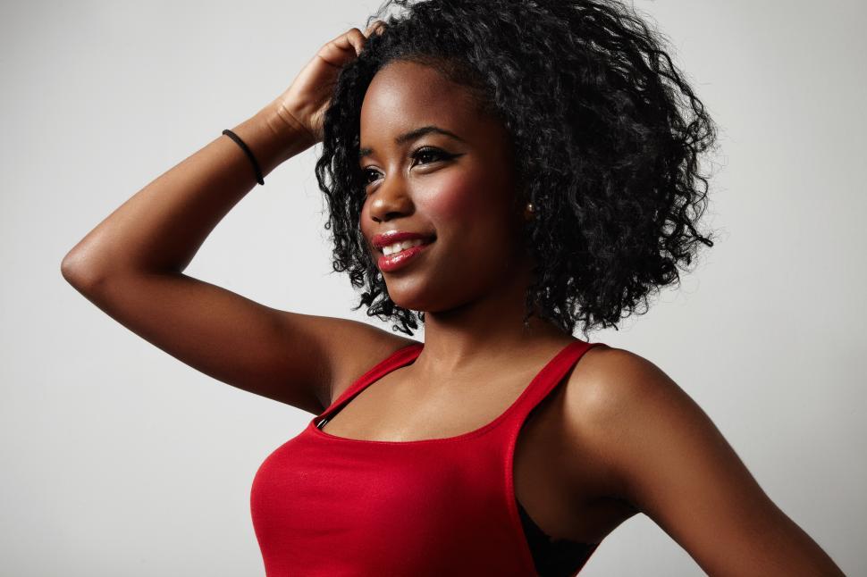 Free Image of black woman with curly hair in red evening slim dress 
