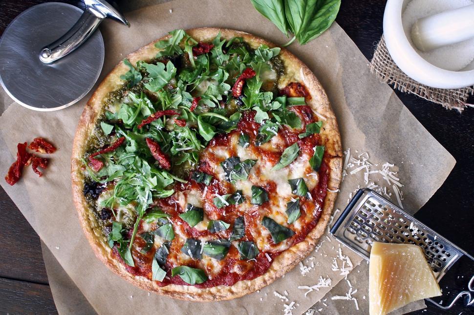 Free Image of A pizza with different toppings on a paper 
