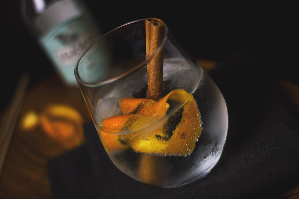 Free Image of A glass with a cinnamon stick and an orange in it 